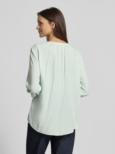 Frauenmodel trägt Comfort Fit Langarmbluse aus reiner Viskose von Tom Tailor mit Allover-Muster in Hellgrün, Ganzkörperansicht Rückansicht.