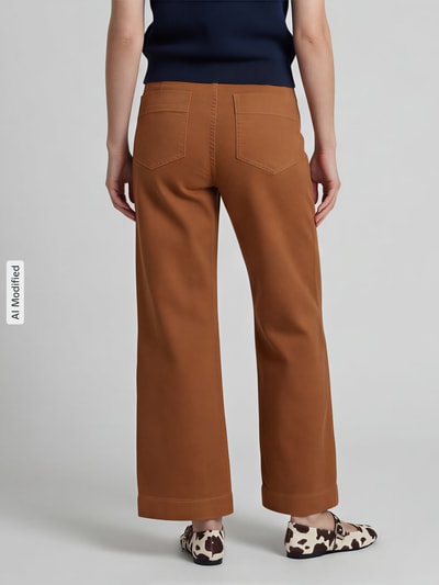 Frauenmodel trägt Hose mit verkürzter Passform mit aufgesetzten Taschen von Jake*s Casual in Braun, sichtbare Gesäßtaschen, Ganzkörperansicht Rückansicht.