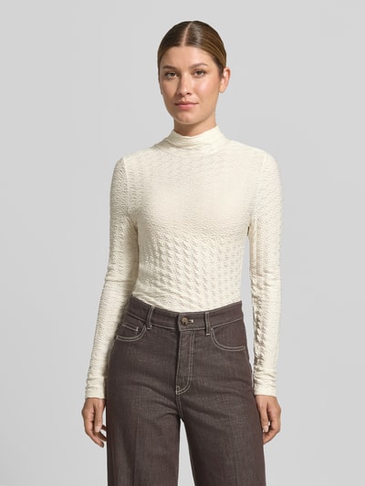 Frauenmodel trägt Skinny Fit Longsleeve aus Viskose-Mix von Marc Cain, cremefarben, Strukturmuster, Stehkragen, Ganzkörperansicht von vorne.