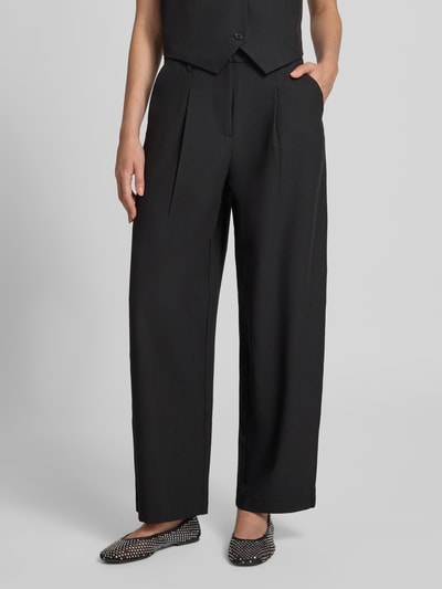 Frauenmodel trägt schwarze Slim Fit Anzughose mit Viskose-Anteil Modell 'BOSELLA' von PIECES, weite Form, glatte Textur, Nahaufnahme Oberkörper.
