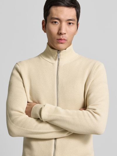 Männermodel trägt Regular Fit Strickjacke aus reiner Baumwolle Modell 'DAME' von SELECTED HOMME in Unifarbe, Nahaufnahme Oberkörper.