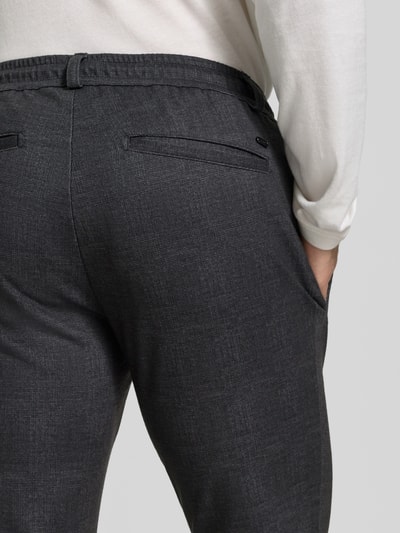 Männermodel trägt Tapered Fit Jogpants aus reiner Baumwolle Modell 'Phil' von Brax in Dunkelgrau mit feiner Textur, Nahaufnahme Rückansicht, Herren Weite Hose von Brax