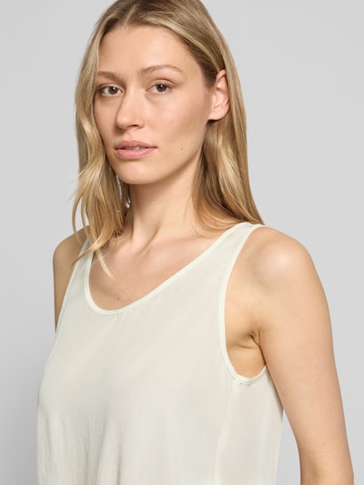 Kobiece model prezentuje Blusenshirt mit Rundhalsausschnitt und Label-Detail od Marc Cain z satyny, krój straight fit, okrągły dekolt, detal z logo, długość tyłu w rozmiarze 36: 52 cm, zbliżenie na górną część ciała z przodu