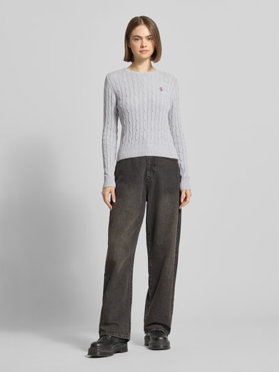 Frauenmodel trägt Strickpullover mit Zopfmuster und Label-Stitching von REVIEW in Hellgrau, Baumwoll-Mix, Regular-Fit, Ganzkörperansicht von vorne.