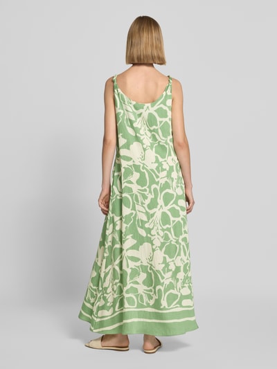 Frauenmodel trägt Midikleid aus Viskose-Mix Modell 'El44ora' von ZABAIONE in Grün mit cremefarbenem Allover-Look, A-Linie, Rückenansicht Ganzkörperansicht.