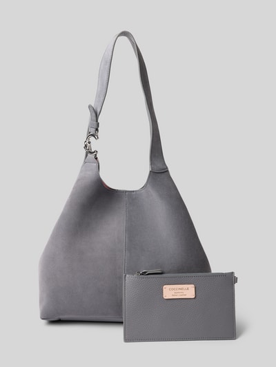 Produktfoto, Tote Bag mit Logo-Detail von Coccinelle in Grau, Magnetverschluss, Schulterriemen, herausnehmbare Innentasche, strukturierte Oberfläche, Breite 36 cm, Länge 29 cm, Tiefe 12 cm, Länge Schulterriemen 54 cm.