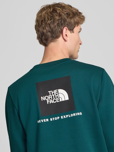 Mannenmodel draagt Regular fit hoodie met logodetail Model "EVOLUTION BOX" van The North Face, katoenmix, ronde hals, elastische boorden, ruglengte maat M 62 cm, mouwlengte maat M 70 cm, rugaanzicht