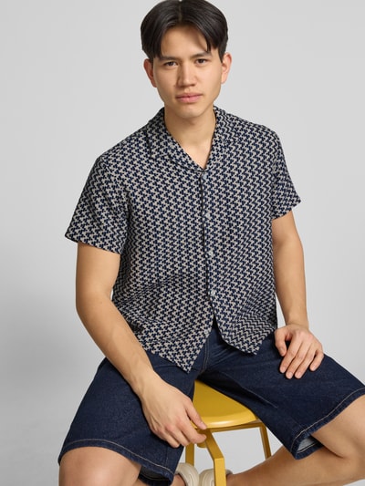 Männermodel trägt Regular Fit Freizeithemd im Allover-Look Modell 'MONTAUK' von Jack & Jones in Blau mit Knopfleiste, Nahaufnahme Oberkörper. Material-Mix mit Baumwoll-Anteil, Reverskragen, kurze Ärmel.