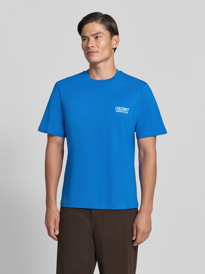 Männermodel trägt Relaxed Fit T-Shirt aus reiner Baumwolle von REVIEW, kräftiges Blau, Motiv-Print, Kurzarm, Ganzkörperansicht von vorne