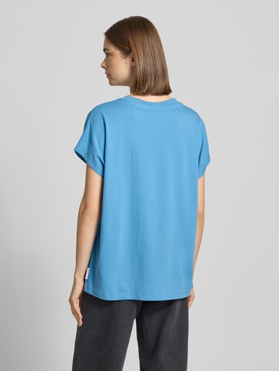 Frauenmodel trägt Oversize T-Shirt aus reiner Baumwolle von Marc O'Polo Denim, Optik: Unifarben, Passform: Oversize, Rundhals, Ärmelform: Kurzarm, Material: Reine Baumwolle, leuchtendes Blau, glatte Textur, Ganzkörperansicht Rückansicht.