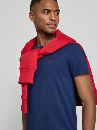 Männermodel trägt T-Shirt mit Label-Detail von Gant in Dunkelblau aus reiner Baumwolle, gerader Schnitt, Rundhalsausschnitt, Nahaufnahme Oberkörper