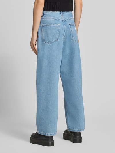 Frauenmodel trägt Wide-Leg-Pants Wide Leg Jeans im 5-Pocket-Design Modell 'Brandon' von Carhartt Work In Progress aus Reine Baumwolle, hellblaue Jeans-Struktur, Ganzkörperansicht Rückansicht.
