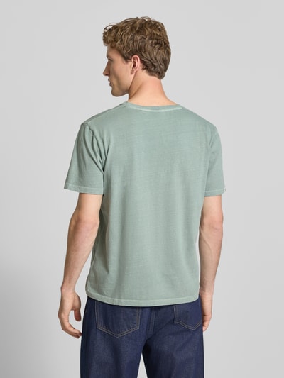 Männermodel trägt T-Shirt aus Baumwoll-Leinen-Mix mit V-Ausschnitt von Superdry in Grün, Regular-Fit, Stitching, Rückenlänge 68 cm, Ganzkörperansicht Rückansicht.
