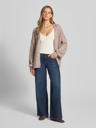 Frauenmodel trägt Regular Fit Strickjacke mit Woll-Anteil Modell 'NELLIE' von ONLY in Beige, dezente Melierung, lockerer Schnitt, Damen Strickjacke, Ganzkörperansicht von vorne.