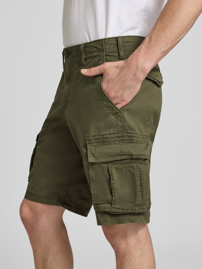 Männermodel trägt Straight Fit Shorts mit Cargo-Taschen Modell 'Core' von GAP in Olivgrün, elastischer Baumwoll-Mix, Nahaufnahme Oberschenkel.