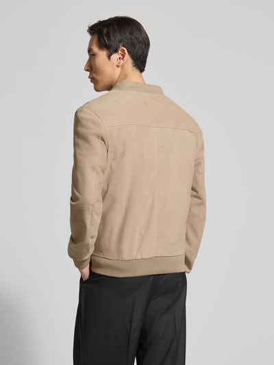 Männermodel trägt Bomberjacke aus Ziegenleder von Profuomo in Beige mit Stehkragen und elastischen Abschlüssen, Ganzkörperansicht Rückansicht.