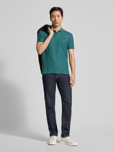 Männermodel trägt Poloshirt mit Logo-Stitching Modell 'PERFORMANCE' von Lerros in Türkis auf Jeans, Baumwoll-Mix, Regular Fit, Ganzkörperansicht von vorne.
