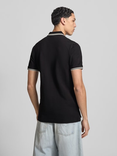 Männermodel trägt Slim Fit Poloshirt mit Logo-Stitching Modell 'Dunda' von G-Star Raw in Schwarz, Baumwoll-Mix, Ganzkörperansicht Rückansicht.