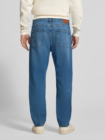Männermodel trägt Slim Straight Fit Jeans aus Baumwoll-Mix Modell 'RYAN' von Tommy Jeans, Denim, Kontrastnähte, Ganzkörperansicht Rückansicht.