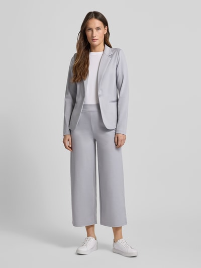 Kobiece model prezentuje Spodnie materiałowe Wide Fit Stoffhose mit Viskose-Anteil Modell 'Kate' von ICHI, elastyczna mieszanka materiałów z dodatkiem wiskozy, kieszeń z tyłu, zakładki w pasie, elastyczny pas, szerokość w rozmiarze S 37 cm, długość wewnętrzna nogawki w rozmiarze S 64 cm, jasnoszary kolor, gładka tekstura, pełny widok z przodu.