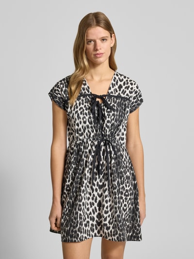 Vrouwenmodel draagt Minikleid met V-hals model 'Liv' van OH APRIL, getailleerd, katoen, strikdetails, zwart-wit print, frontale volledige lichaamsweergave.