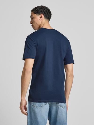 Męski model nosi T-Shirt mit Label-Stitching Modell 'CASSICA' od Ellesse, czysta bawełna, krój regular fit, kolor granatowy, widok całej sylwetki od tyłu.