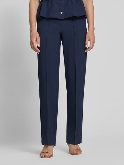 Frauenmodel trägt Straight Fit Stoffhose mit Logo-Detail Modell 'Paulien' von JOOP! in Dunkelblau, Ziernaht, elastischer Bund, Nahaufnahme Oberkörper.