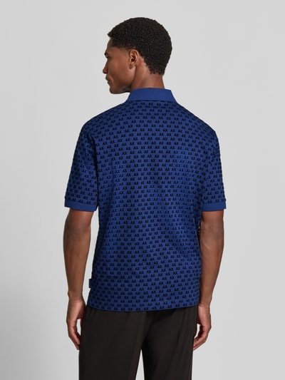 Männermodel trägt Regular Fit Poloshirt aus reiner Baumwolle von Armani Exchange in Blau mit Allover-Logo-Print, Rückenansicht, Ganzkörperansicht Rückansicht.