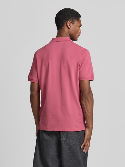 Männermodel trägt Regular Fit Poloshirt aus reiner Baumwolle von Tom Tailor in Rosa mit glatter Textur, Ganzkörperansicht Rückansicht.