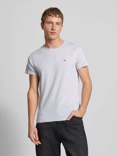 Männermodel trägt Regular Fit T-Shirt aus reiner Baumwolle von Tommy Jeans, Optik: Melange, Logo-Stitching, Nahaufnahme Oberkörper.