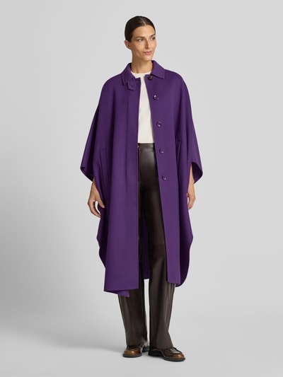 Frauenmodel trägt Overzized Mantel im Poncho-Style Modell 'PAGGIO' von Weekend Max Mara in kräftigem Lila, glatte Textur, Ganzkörperansicht von vorne.