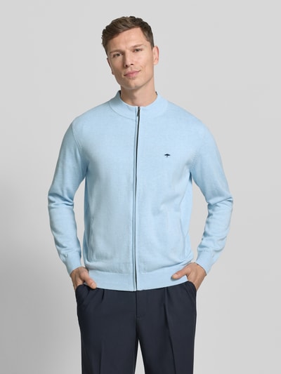 Männermodel trägt Strickjacke mit Reißverschluss von Fynch-Hatton in Hellblau aus reiner Baumwolle, Regular-Fit, Gerippte-Abschlüsse, Stehkragen, Label-Stitching, Eingrifftaschen, Rückenlänge 67 cm, Ärmellänge 69 cm, Ganzkörperansicht von vorne.