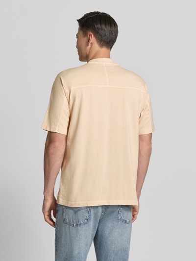 Männermodel trägt Relaxed Fit T-Shirt aus reiner Baumwolle Modell 'TE_TILE' von BOSS Orange in Beige, unifarben mit Rückennaht, Ganzkörperansicht Rückansicht.