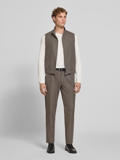 Männermodel trägt Weste mit Stretch-Anteil von ROY ROBSON in Braun, kombiniert mit weißem Oberteil und Stoffhose, Ganzkörperansicht von vorne. Regular Fit, Stehkragen, Reißverschluss, Eingrifftaschen, elastischer Material-Mix und Bund, Rückenlänge 62 cm, Schulterbreite 39 cm, Brustweite 58 cm.