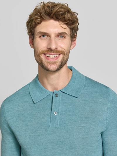 Männermodel trägt Regular Fit Poloshirt aus Woll-Mix von Christian Berg Men in Hellblau, feine Struktur, gerippte Abschlüsse, Nahaufnahme Oberkörper.