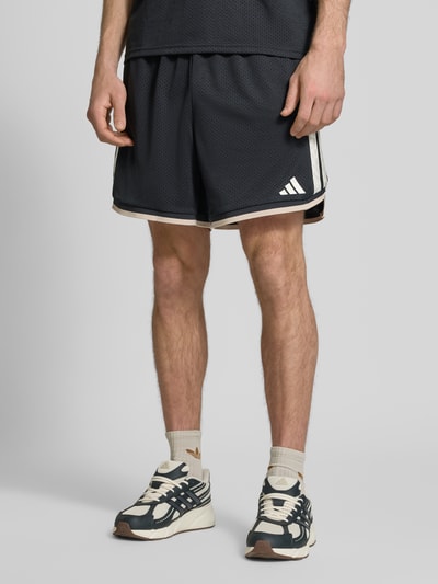 Mężczyzna nosi Shorts mit elastischem Bund und Kordelzug von adidas Sportswear, luźny krój, logo, ciemny kolor, Szerokość w rozmiarze M: 39 cm, długość nogawki od wewnątrz: 16 cm, Ganzkörperansicht z przodu
