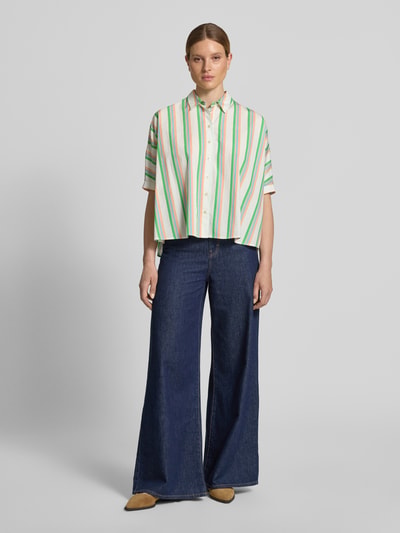 Frauenmodel trägt Relaxed Fit Bluse im Allover-Look von Emily Van den Bergh aus reiner Baumwolle mit Hemdblusenkragen, Knopfleiste und 1/2-Arm, Mehrfarbenstreifen, Ganzkörperansicht von vorne.