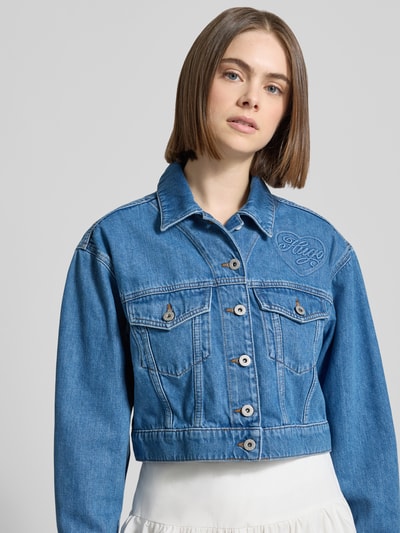 Frauenmodel trägt Regular Fit Jeansjacke Baumwoll-Mix Modell 'GALATEA_B' von Hugo Blue, Denim-Optik, Pattentaschen, Nahaufnahme Oberkörper.