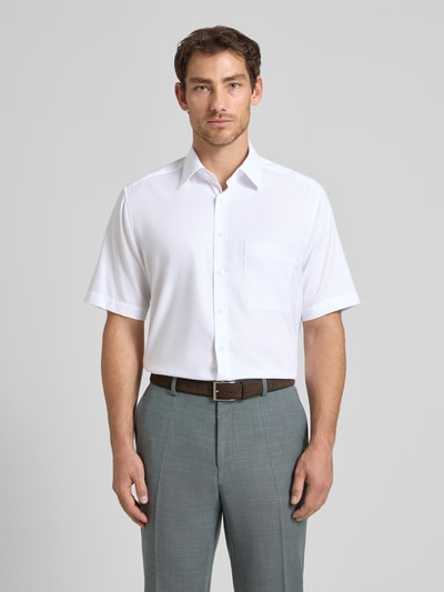 Męski model nosi Comfort Fit Business-Hemd aus Baumwolle mit Kentkragen od ETERNA, kolor biały, listwa guzikowa, brustasza, rękaw o dł. 1/2, widok na cały przód sylwetki. Długość tyłu w rozmiarze 40: 80 cm, szerokość ramion w rozmiarze 40: 45 cm, długość rękawów w rozmiarze 40: 30 cm.