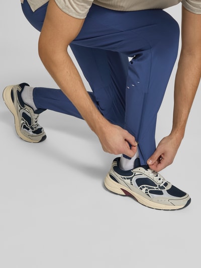Männermodel trägt Slim Fit Trainingshose mit Dri-FIT-Technologie Modell 'Stride' von Nike in Blau, Nahaufnahme Beine, Herren Trainingshose von Nike Training.