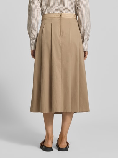 Kobiece model prezentuje spódnica midi z wszytym zamkiem błyskawicznym model 'Vivian' od Raffaello Rossi, beżowa, gładka faktura, szerokość w rozmiarze 36: 38 cm, całkowita długość: 81 cm, wyhaftowane logo, zakładki, widok całej sylwetki z tyłu.