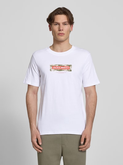 Männermodel trägt T-Shirt mit Logo und Rundhalsausschnitt von Jack & Jones, weiß, aus reiner Baumwolle, Regular Fit, Ganzkörperansicht von vorne.