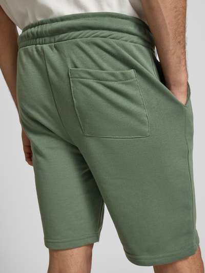 Männermodel trägt Sweatshorts mit elastischem Bund Modell 'KARLOS' von Blend in Grün, Baumwoll-Mix, Regular Fit, Ganzkörperansicht Rückansicht.