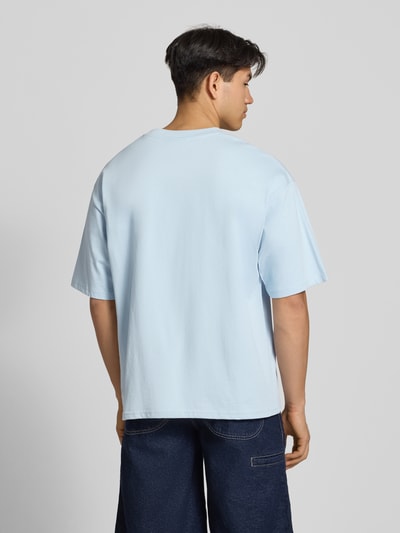 Männermodel trägt T-Shirt mit Label-Stitching und Rundhalsausschnitt von REVIEW in Hellblau, Relaxed-Fit aus Reine Baumwolle, Rückenlänge 70 cm, Ganzkörperansicht Rückansicht.