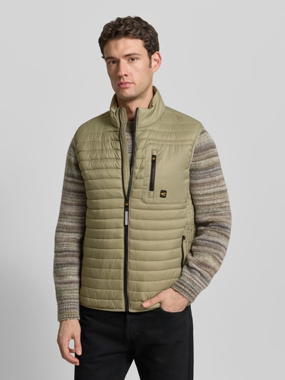 Männermodel draagt Steppweste mit Stehkragen van camel active in regular fit met ritssluiting, borstzak met ritssluiting, labeldetail, steekzakken, kleur lichtbruin, structuur horizontaal doorgestikt, ruglengte maat M 68 cm, schouderbreedte 46 cm, borstwijdte 60 cm. Nahaufnahme oberkörper.