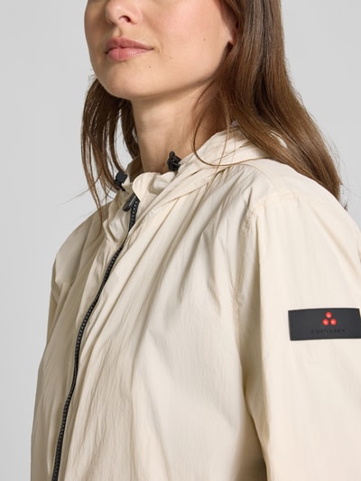Frauenmodel trägt Peuterey Regular Fit Jacke mit Kapuze Modell 'Nigle', helle Farbe, Zweiwege-Reißverschluss, Eingrifftaschen, Nahaufnahme Oberkörper. Rückenlänge 60 cm, Schulterbreite 47 cm, Brustweite 57 cm, Ärmellänge 61 cm bei Größe 38.