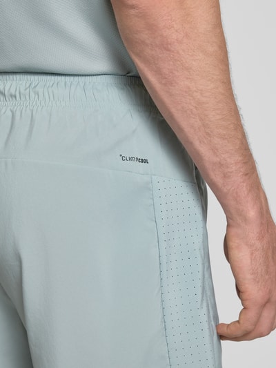 Männermodel trägt Regular Fit Shorts mit Logo-Print von adidas Training, elastischer Bund und Reißverschlusstasche, Nahaufnahme Rückansicht.