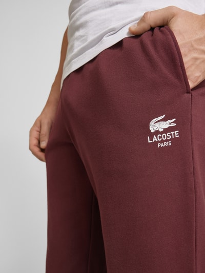 Lacoste Spodnie dresowe o kroju tapered fit z nadrukiem z logo model ‘HERITAGE’ Bordowy 3