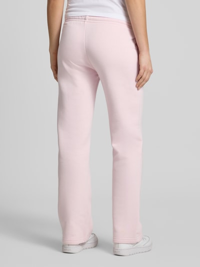 Frauenmodel trägt Sweatpants mit elastischem Bund Modell 'Iconic' von Gina Tricot in Rosa, Baumwoll-Mix, Relaxed-Fit, Ganzkörperansicht Rückansicht.