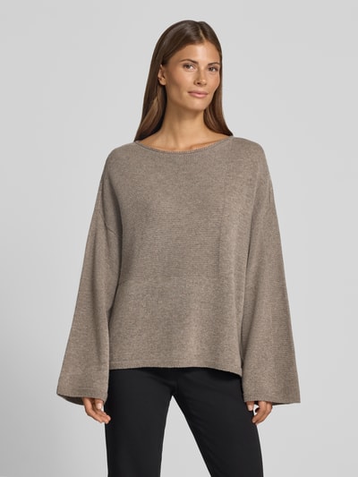 Frauenmodel trägt Oversized Pullover aus reiner Baumwolle in Strick-Optik von Emporio Armani, beige, lockerer Schnitt, Ganzkörperansicht von vorne.